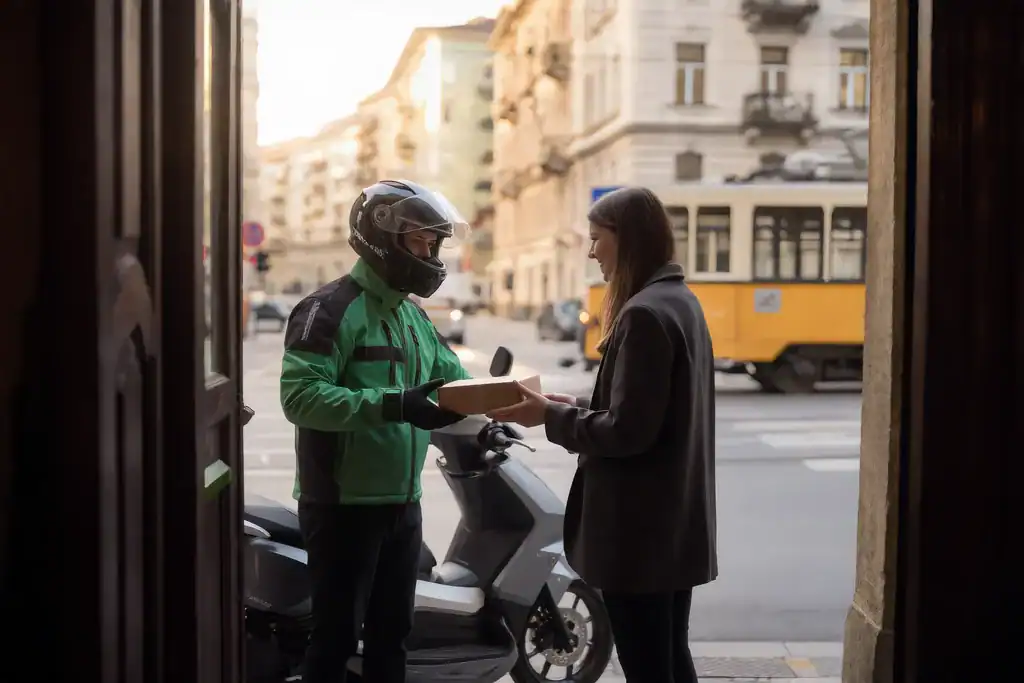PikkPakk motoros futár csomagot ad át az ügyfélnek Budapesten